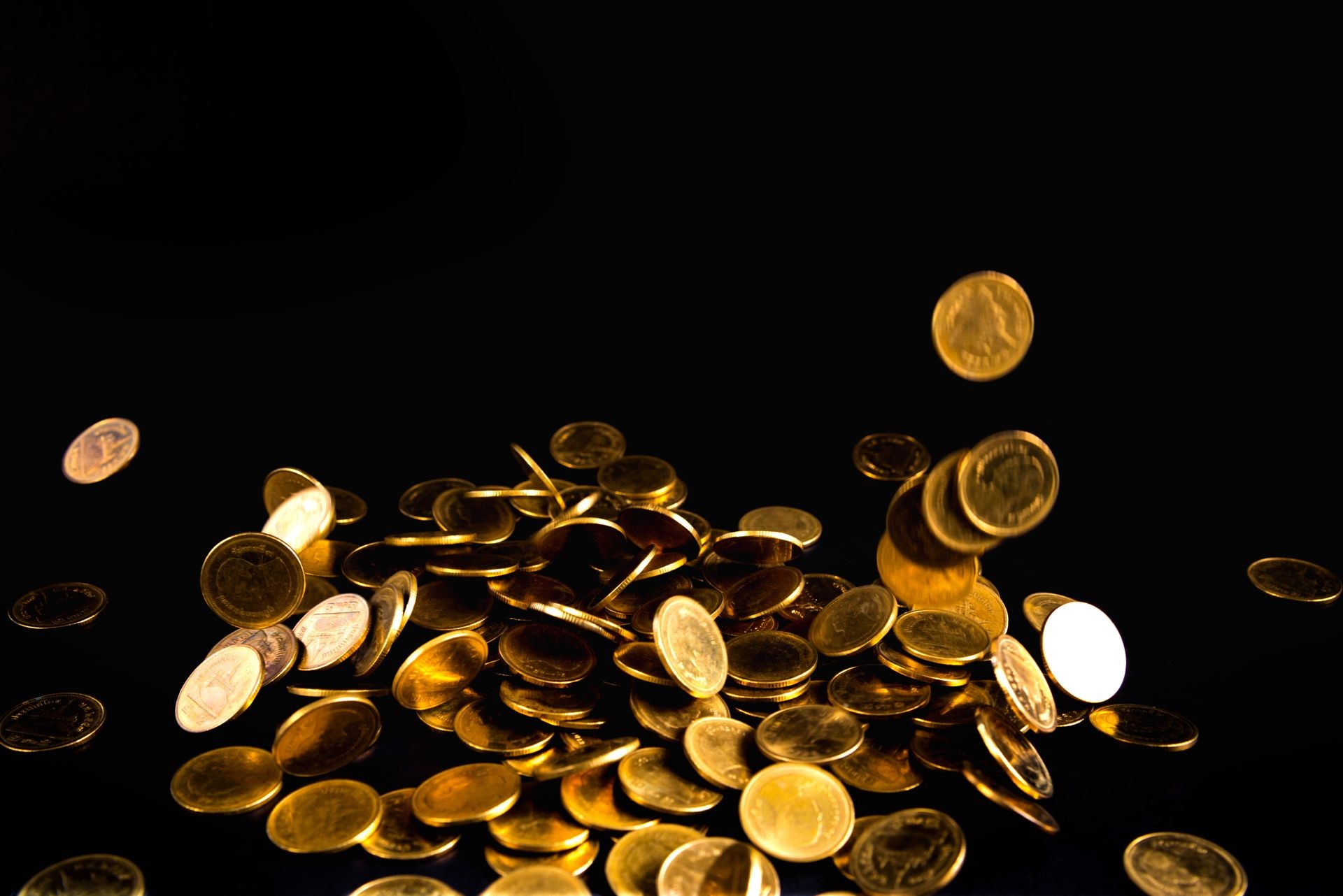 Falling gold coins money in dark background, business concept idea.